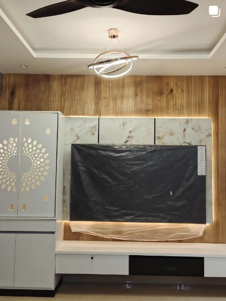 Living room media wall with fluted wood panelling, marble cladding and backlit console